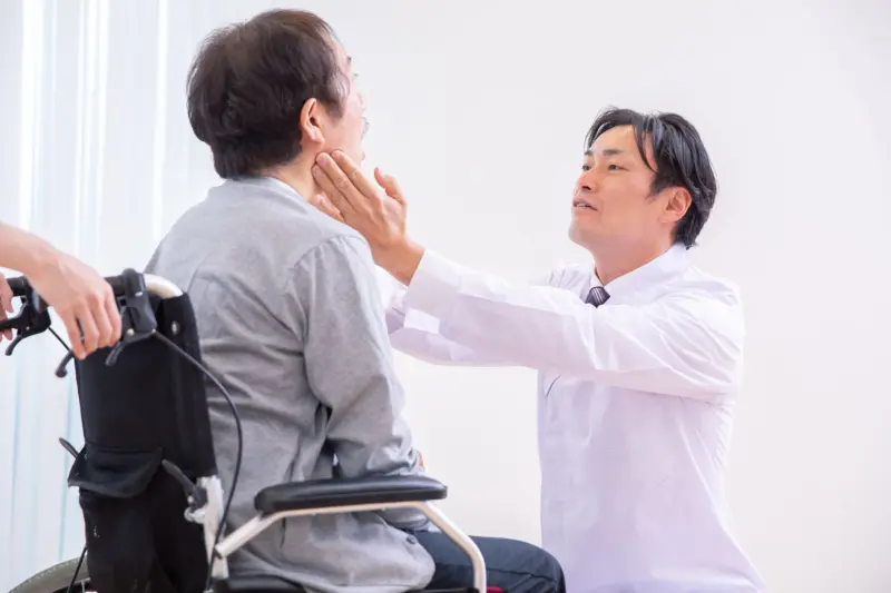 高齢者の歯を見る人