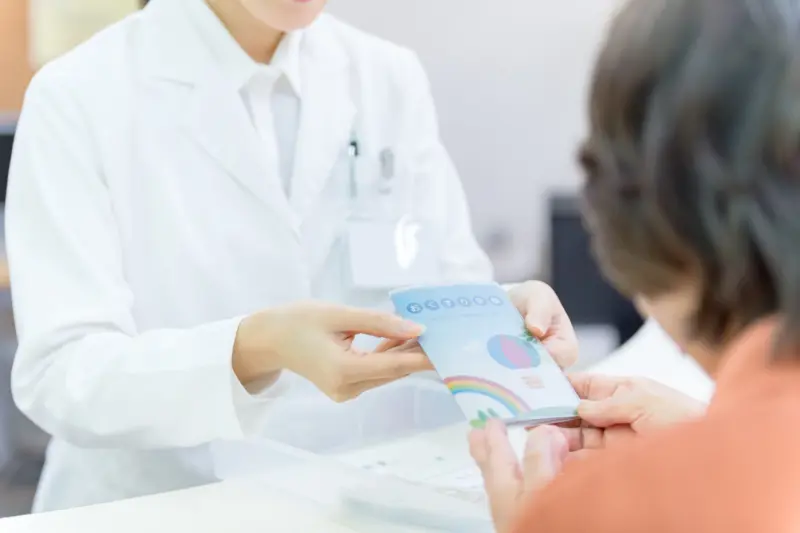 お薬手帳を受け取る調剤事務管理士